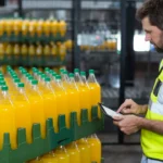 U.S. softdrink manufacturing factory showing a worker who are maintaining record of juice bottles