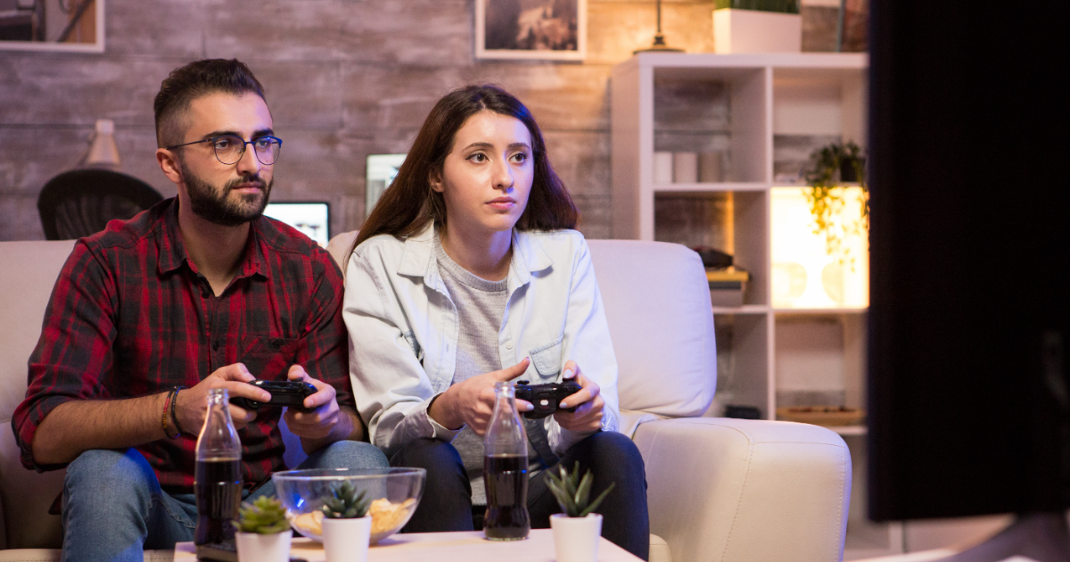 a couple enjoying video games with gaming consoles