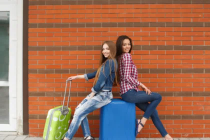 Two female friends travelling along with their travel bags